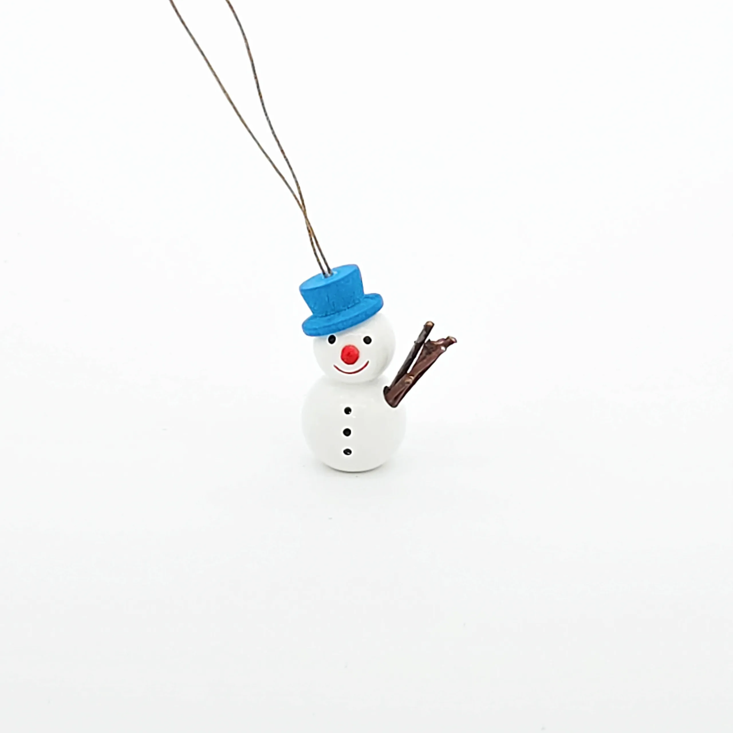 kleine weiße Schneemänner hängend mit blauem Hut