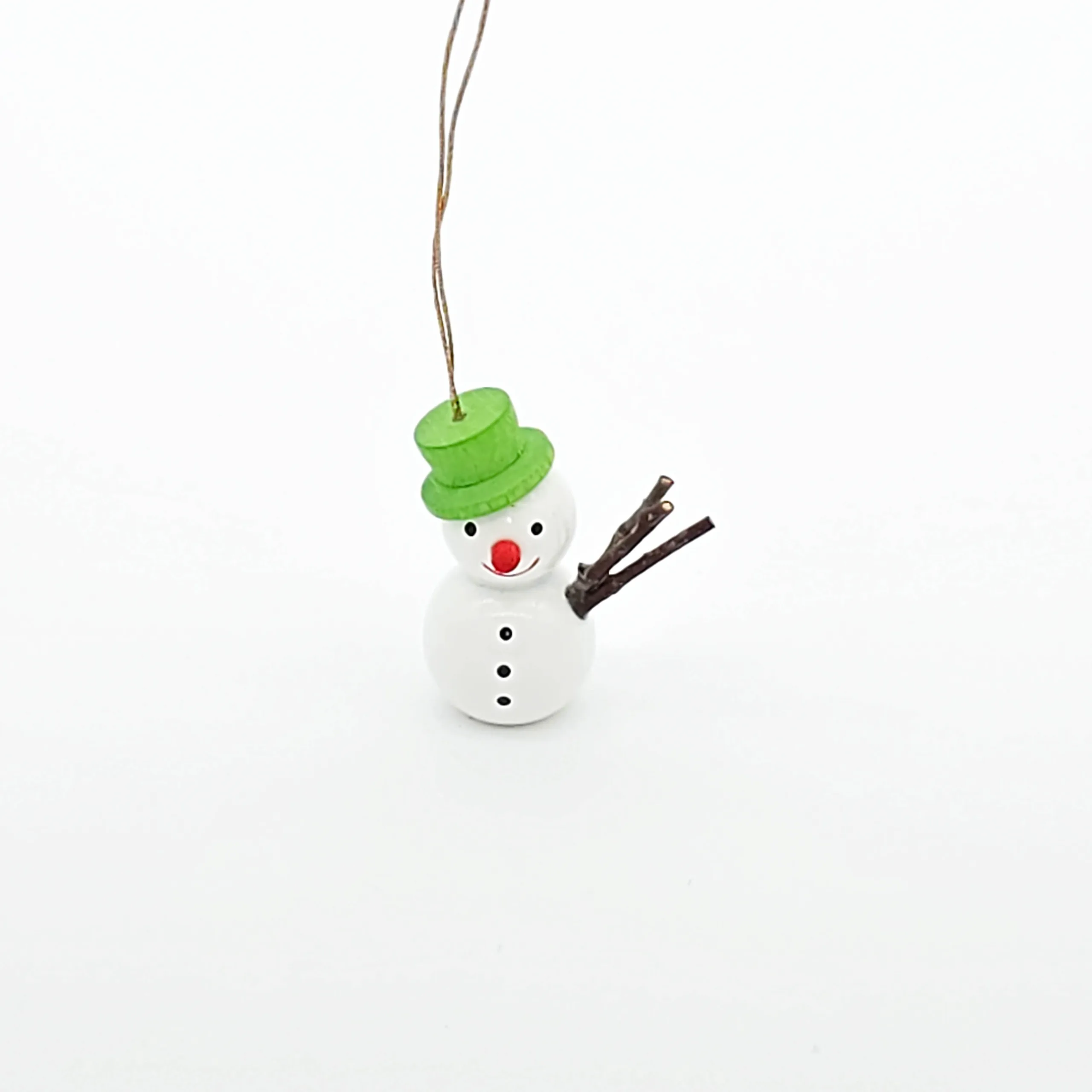 kleine weiße Schneemänner hängend mit grünem Hut