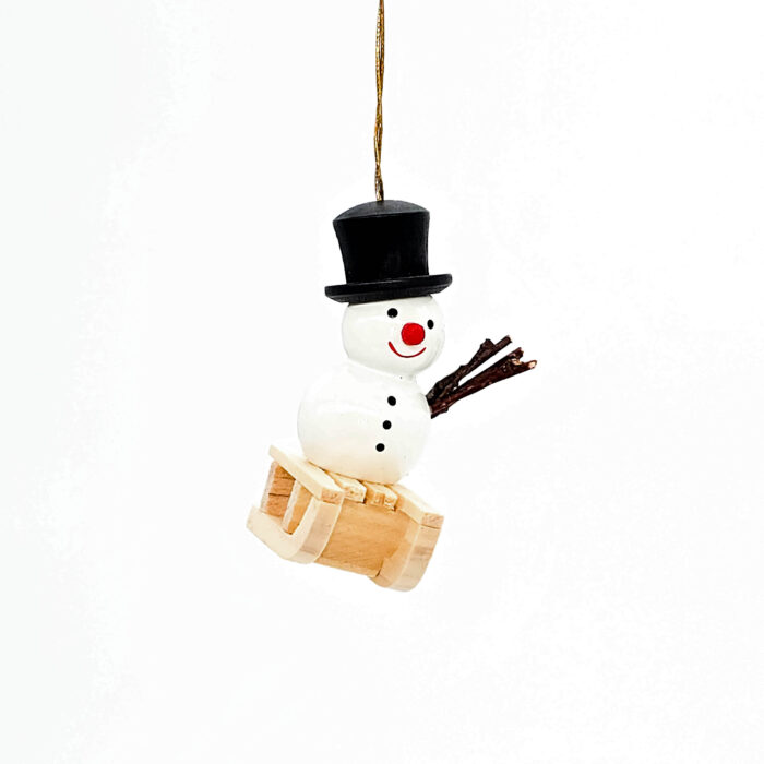 kleiner weißer Holzschneemann hängend mit Schlitten