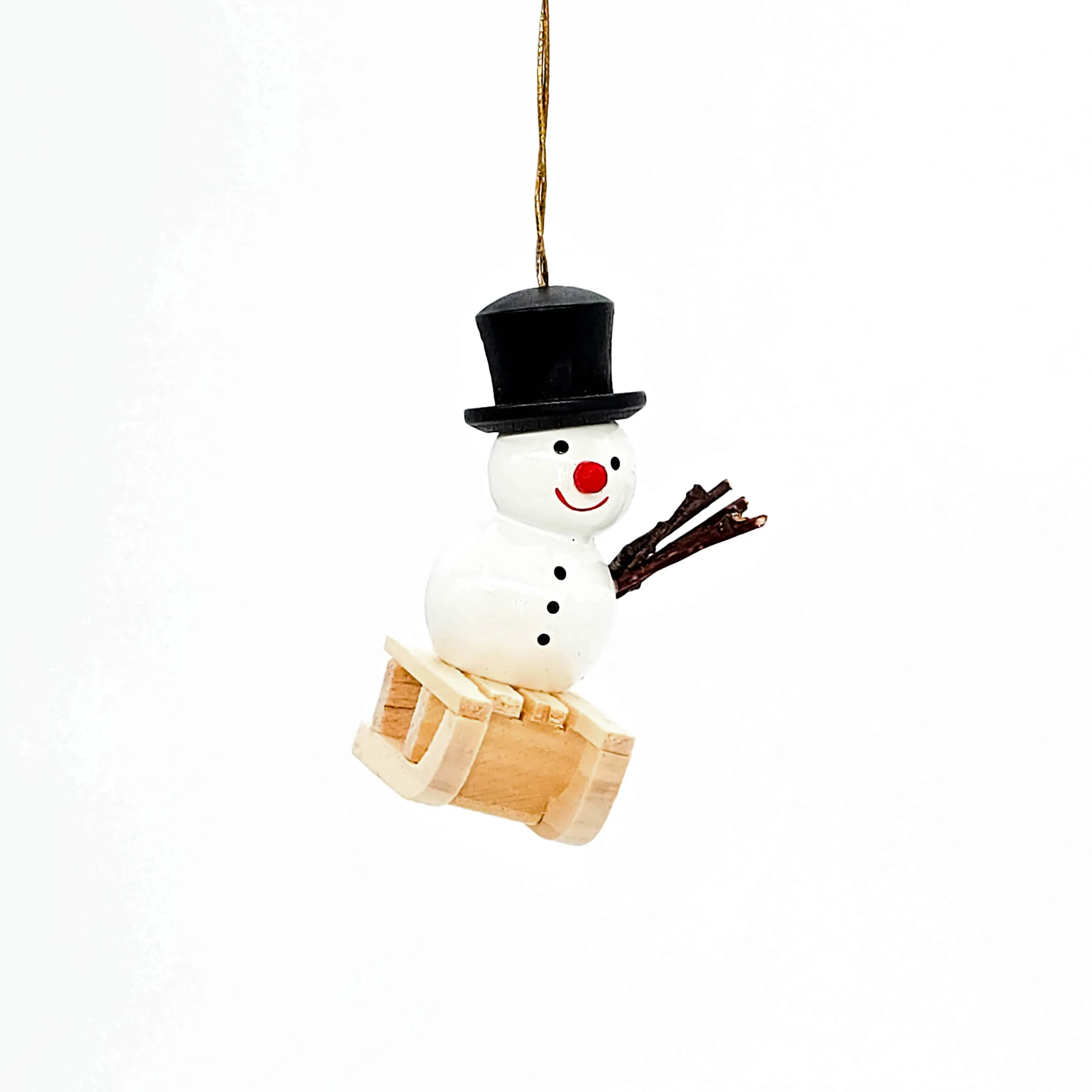kleiner weißer Holzschneemann hängend mit Schlitten