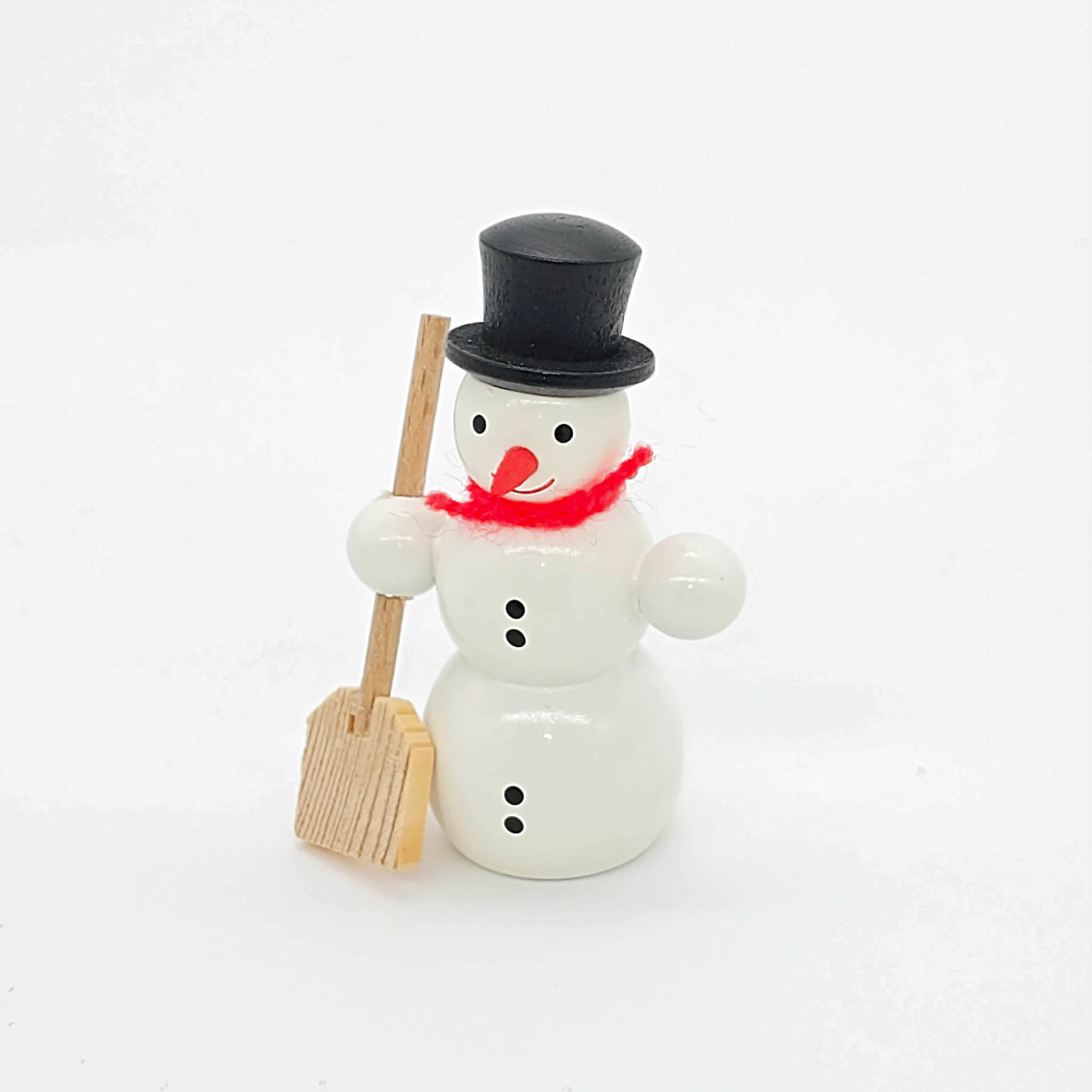 kleiner weißer Holzschneemann mit Schippe