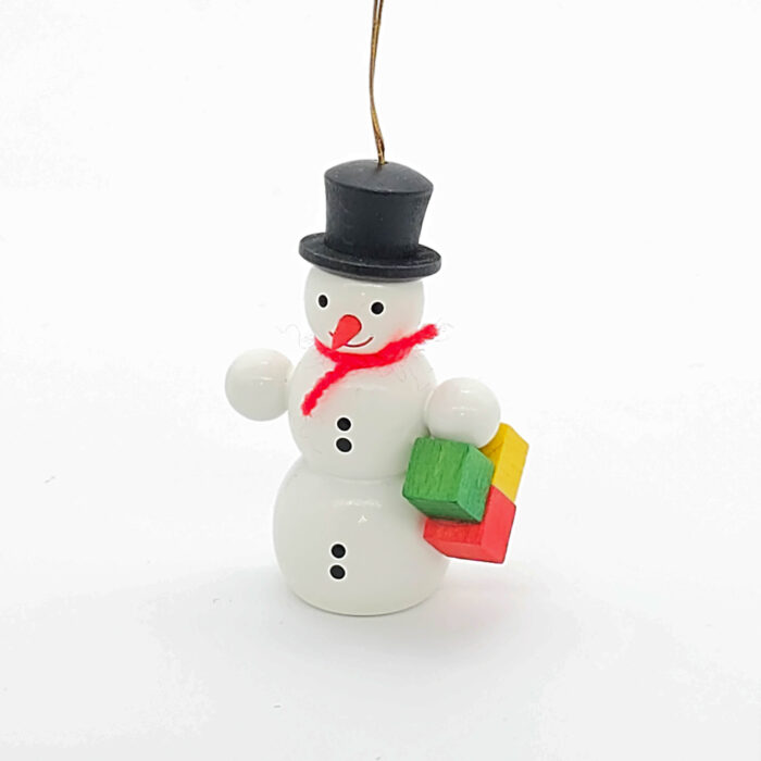 kleiner weißer Holzschneemann hängend mit Paket