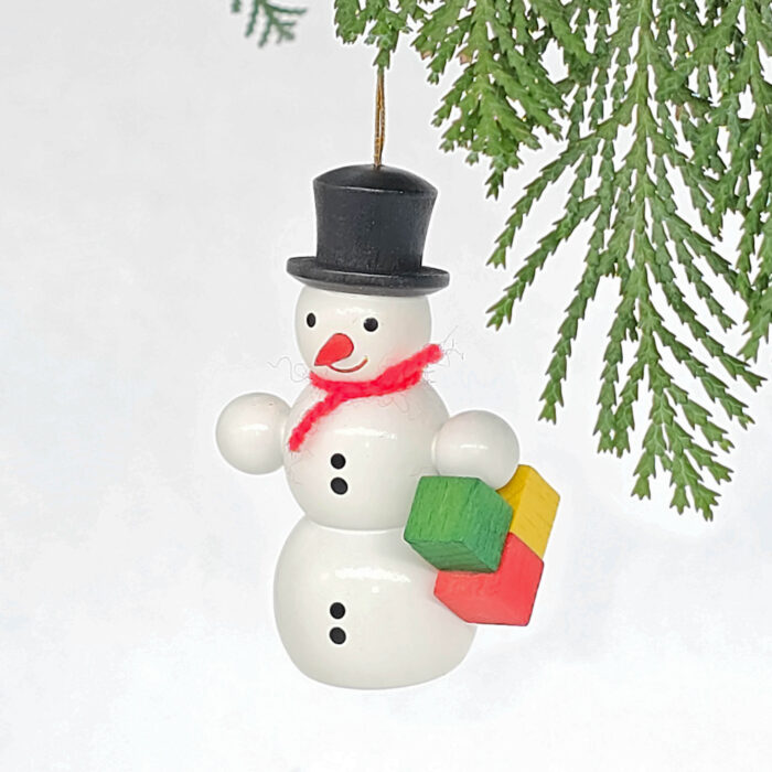kleiner weißer Holzschneemann hängend mit Paket