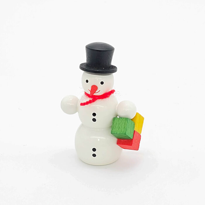 kleiner weißer Holzschneemann mit Paket
