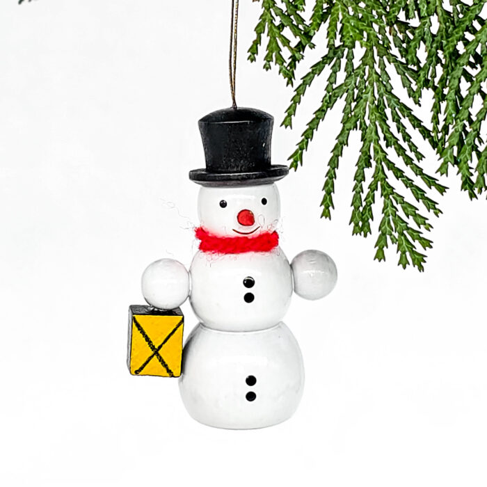 kleiner weißer Holzschneemann hängend mit Laterne