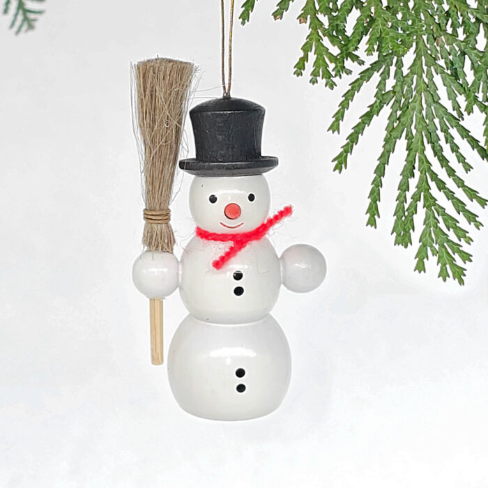kleiner weißer Holzschneemann hängend mit Besen
