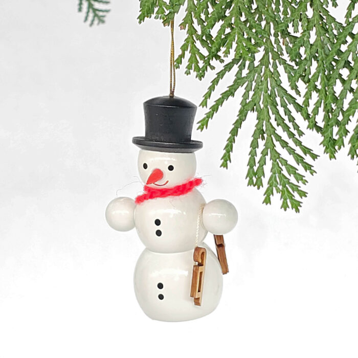 kleiner weißer Holzschneemann hängend mit Schlittschuh