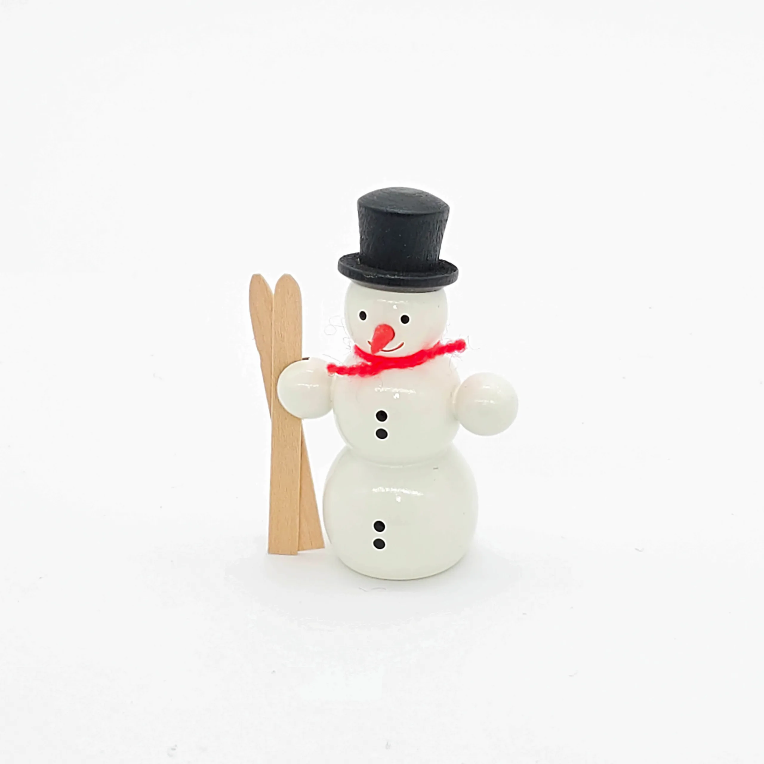 kleiner weißer Holzschneemann mit Ski
